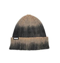 A ribbed knit beanie hat with a brown and black gradient ombre design, featuring a black and white 'MHD' logo patch 