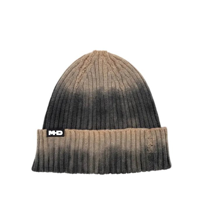 A ribbed knit beanie hat with a brown and black gradient ombre design, featuring a black and white 'MHD' logo patch 